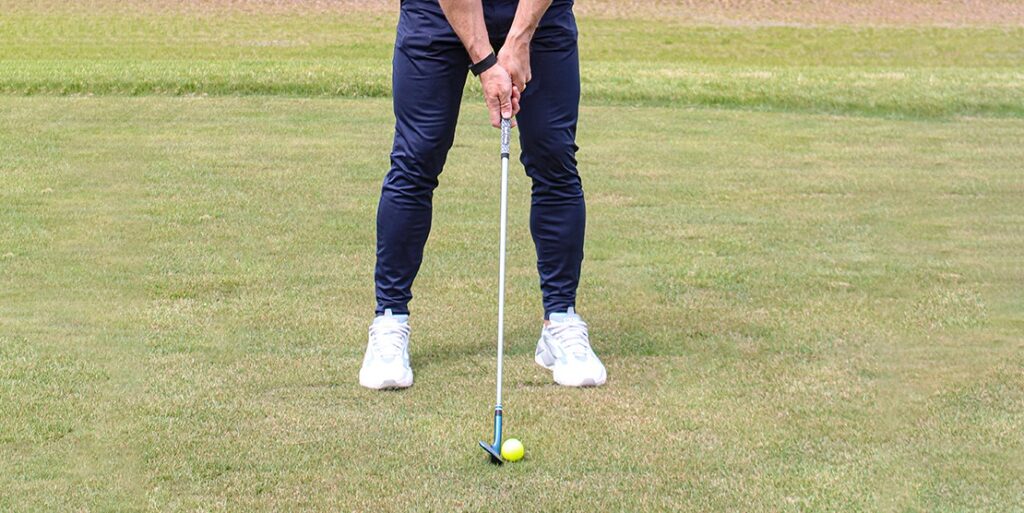 Golfer attempting to putt a hole on a scenic golf course, illustrating the concept of challenging oneself for golf improvement