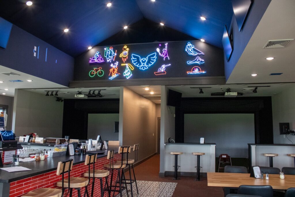 slice-pizzeria-sports-bar-at-owls-nest-with-neon-lights-and-bar-seating